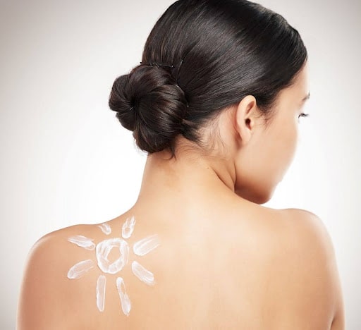 woman faces away with a sun shining on her back